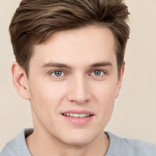 Joyful white young-adult male with short  brown hair and grey eyes