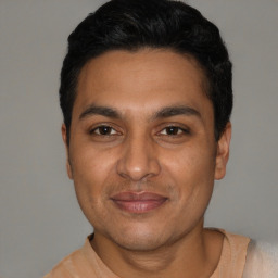 Joyful latino young-adult male with short  black hair and brown eyes