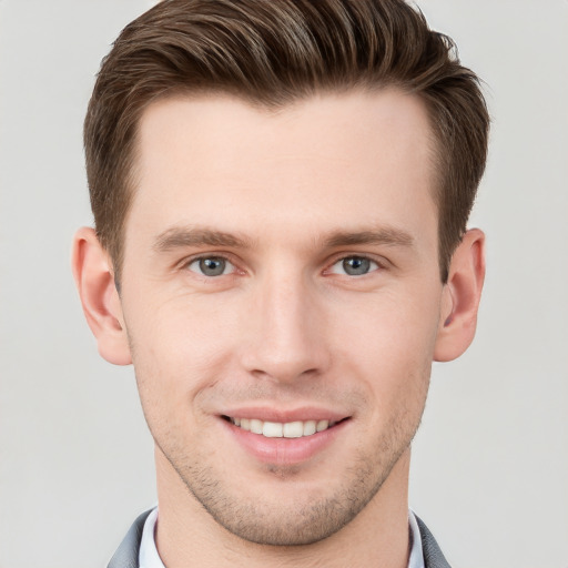 Joyful white young-adult male with short  brown hair and grey eyes