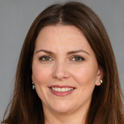 Joyful white adult female with long  brown hair and brown eyes