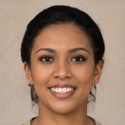 Joyful latino young-adult female with medium  brown hair and brown eyes