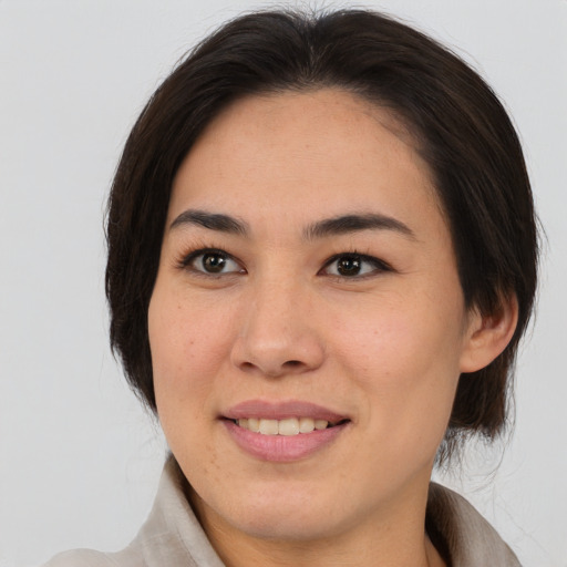 Joyful asian young-adult female with medium  brown hair and brown eyes