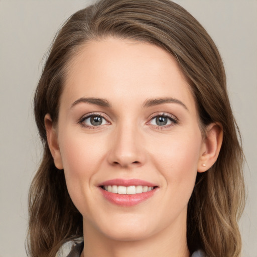 Joyful white young-adult female with long  brown hair and grey eyes