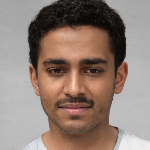 Joyful white young-adult male with short  black hair and brown eyes