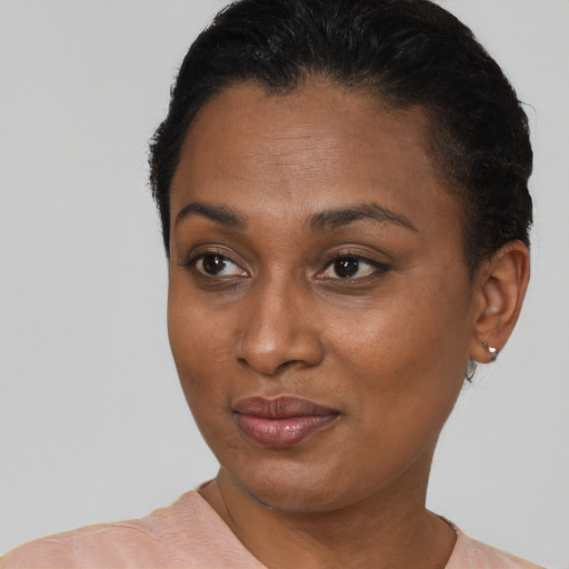 Joyful black young-adult female with short  brown hair and brown eyes