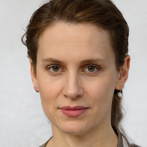 Joyful white young-adult female with short  brown hair and green eyes