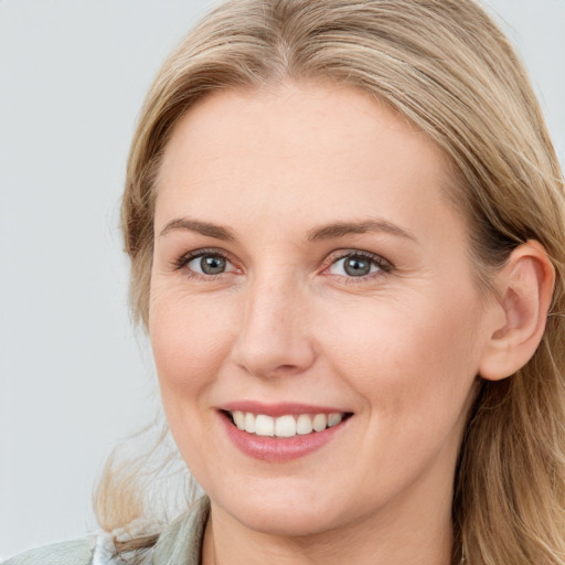 Joyful white young-adult female with long  brown hair and blue eyes