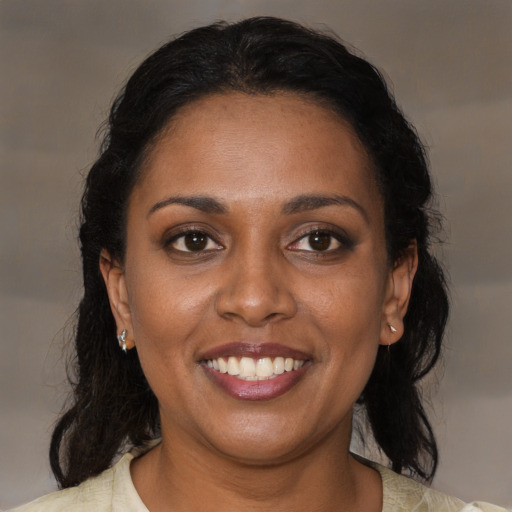 Joyful black adult female with medium  brown hair and brown eyes
