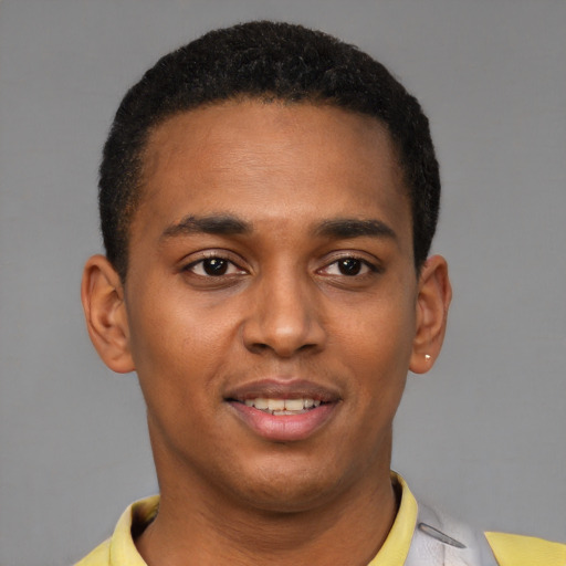 Joyful black young-adult male with short  brown hair and brown eyes
