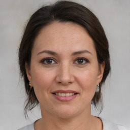 Joyful white adult female with medium  brown hair and brown eyes