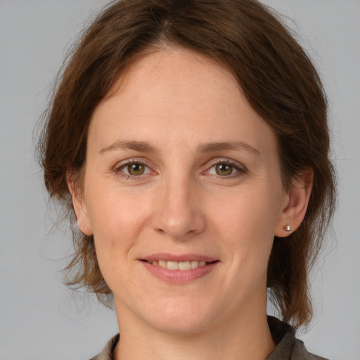 Joyful white young-adult female with medium  brown hair and green eyes