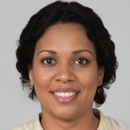 Joyful black adult female with medium  brown hair and brown eyes