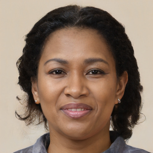 Joyful black adult female with medium  brown hair and brown eyes