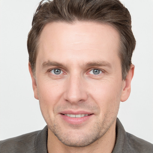 Joyful white young-adult male with short  brown hair and grey eyes