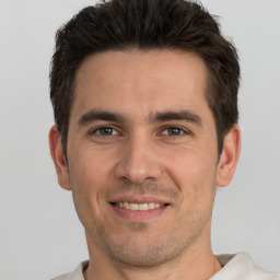 Joyful white young-adult male with short  brown hair and brown eyes