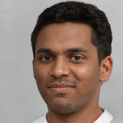 Joyful black young-adult male with short  black hair and brown eyes