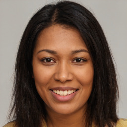 Joyful black young-adult female with long  brown hair and brown eyes