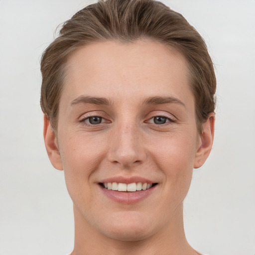 Joyful white young-adult female with short  brown hair and grey eyes