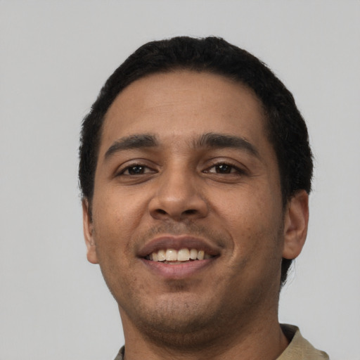 Joyful latino young-adult male with short  black hair and brown eyes