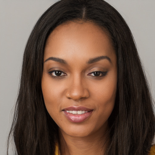 Joyful black young-adult female with long  brown hair and brown eyes