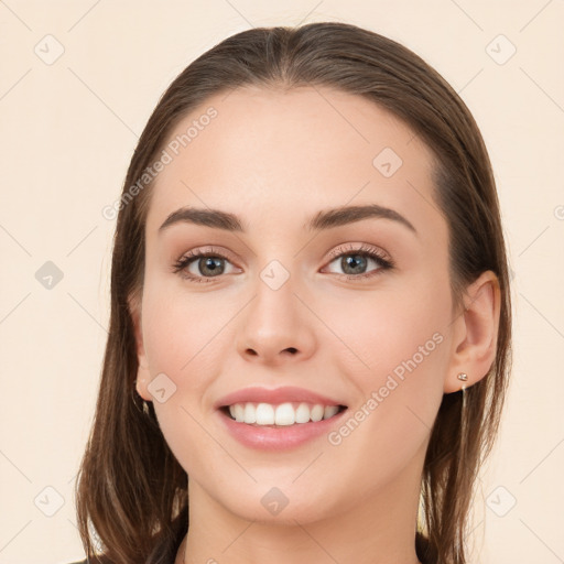 Joyful white young-adult female with long  brown hair and brown eyes