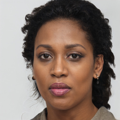 Joyful black young-adult female with long  black hair and brown eyes