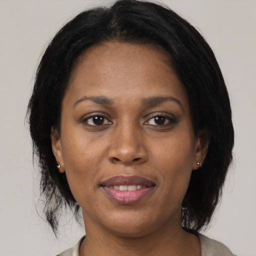 Joyful black adult female with medium  brown hair and brown eyes