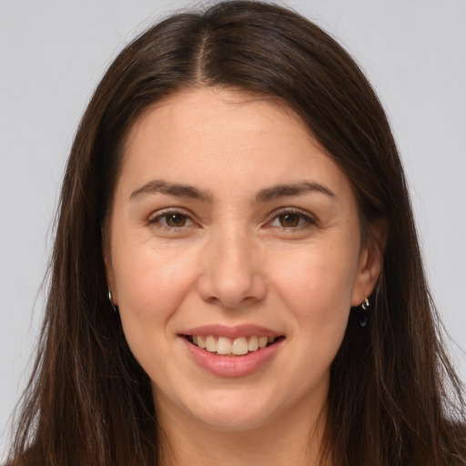 Joyful white young-adult female with long  brown hair and brown eyes