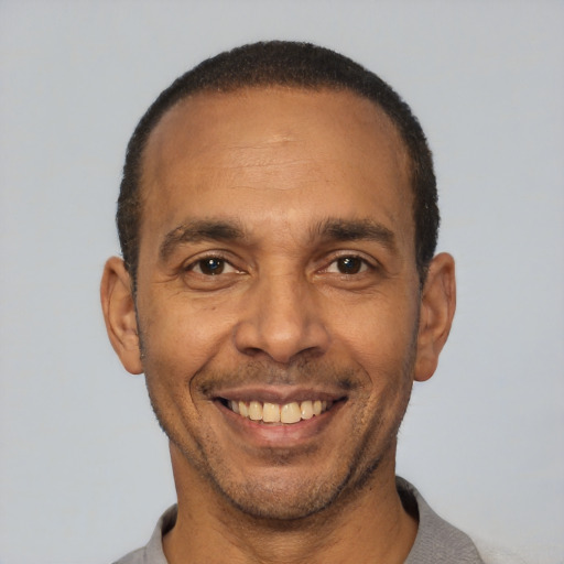 Joyful latino adult male with short  black hair and brown eyes