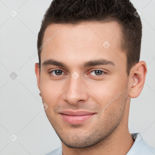 Joyful white young-adult male with short  brown hair and brown eyes