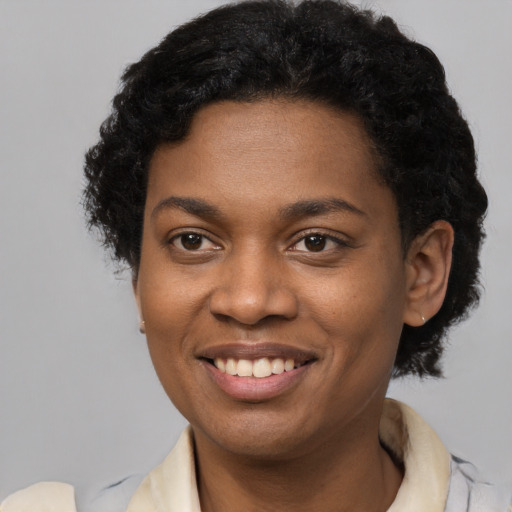 Joyful black young-adult female with short  black hair and brown eyes