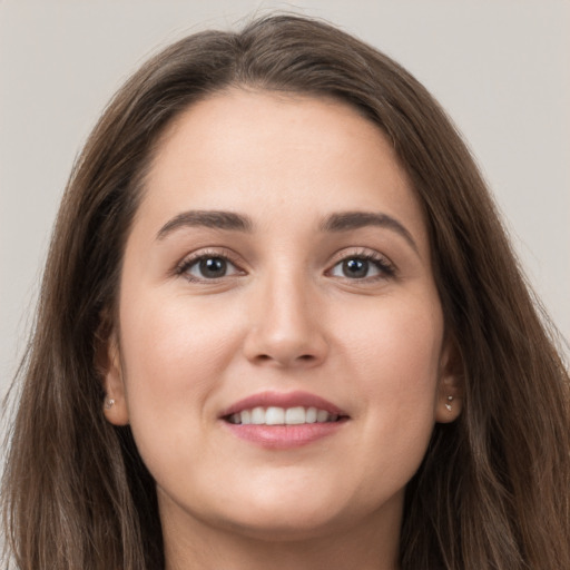 Joyful white young-adult female with long  brown hair and grey eyes