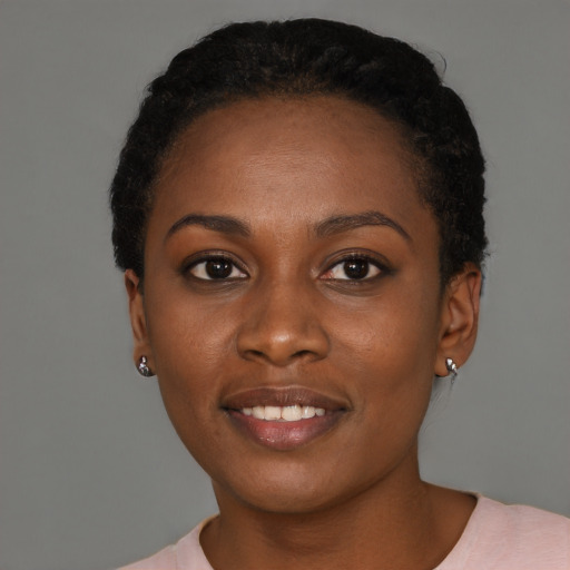 Joyful black young-adult female with short  brown hair and brown eyes