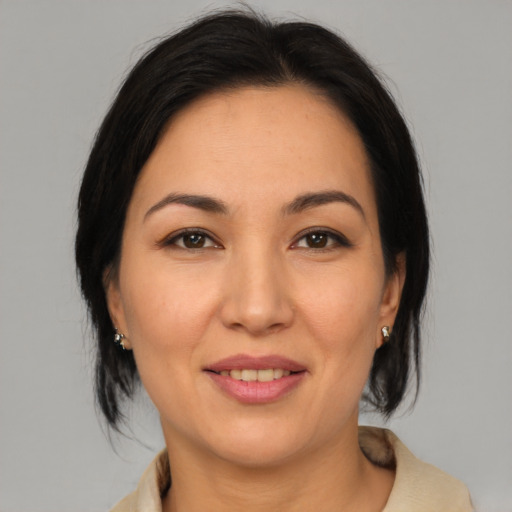 Joyful asian adult female with medium  brown hair and brown eyes