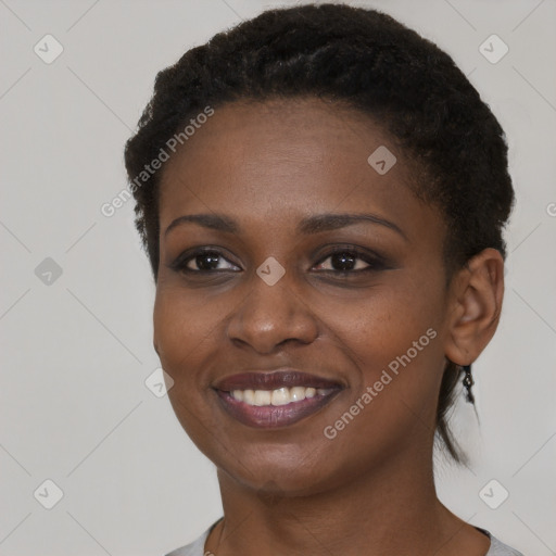 Joyful black young-adult female with short  black hair and brown eyes