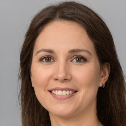 Joyful white young-adult female with long  brown hair and green eyes