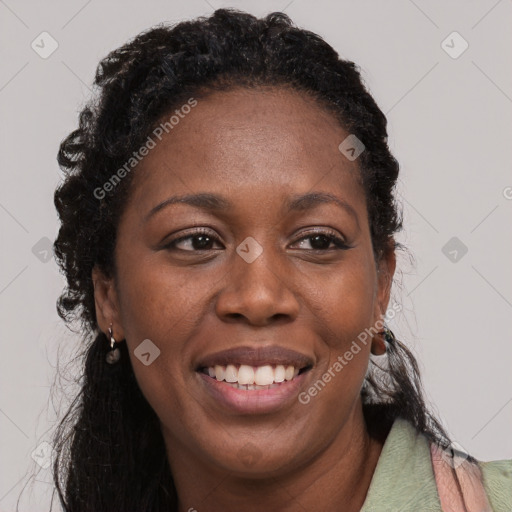 Joyful black adult female with long  black hair and brown eyes