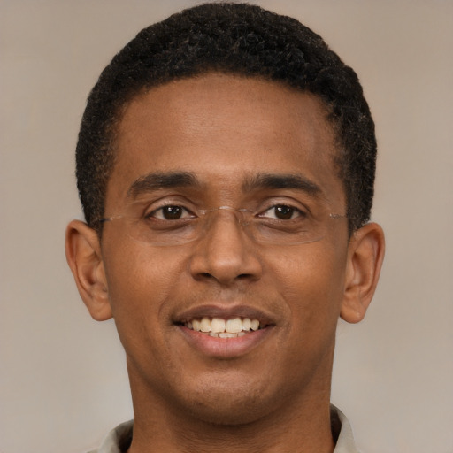 Joyful black young-adult male with short  brown hair and brown eyes