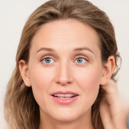 Joyful white young-adult female with long  brown hair and blue eyes