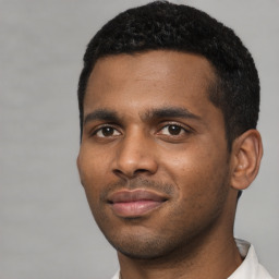 Joyful black young-adult male with short  black hair and brown eyes