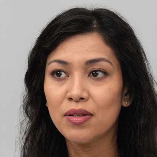Joyful latino adult female with long  brown hair and brown eyes