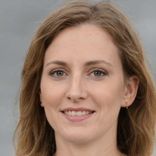 Joyful white young-adult female with medium  brown hair and green eyes