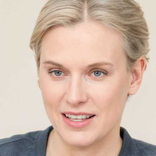 Joyful white adult female with medium  brown hair and blue eyes