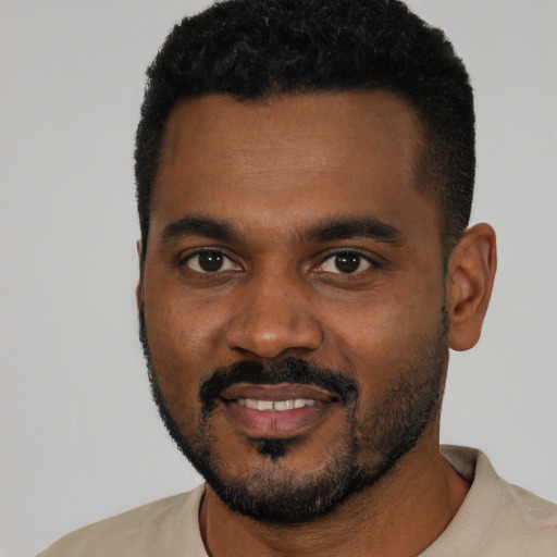 Joyful black young-adult male with short  black hair and brown eyes