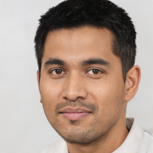 Joyful latino young-adult male with short  black hair and brown eyes