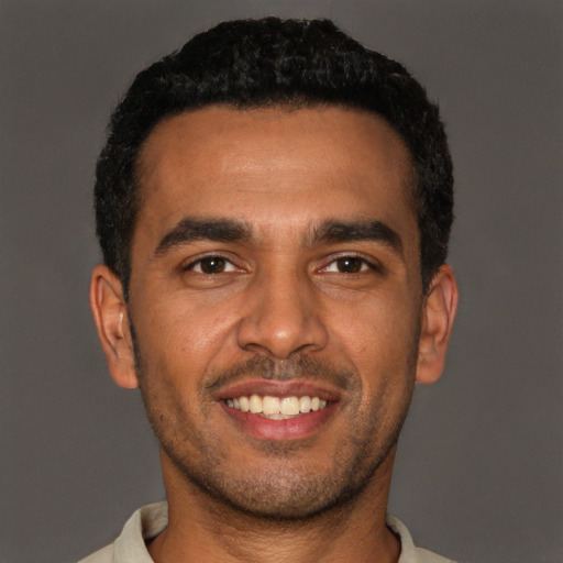 Joyful black young-adult male with short  black hair and brown eyes