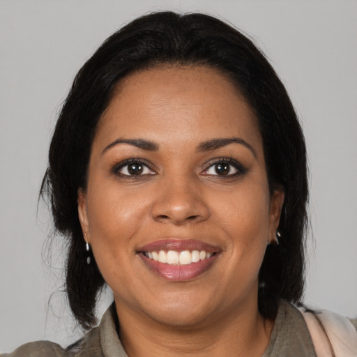Joyful black adult female with medium  brown hair and brown eyes