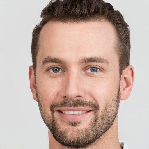 Joyful white young-adult male with short  brown hair and grey eyes