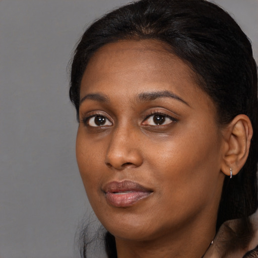 Joyful black young-adult female with medium  brown hair and brown eyes