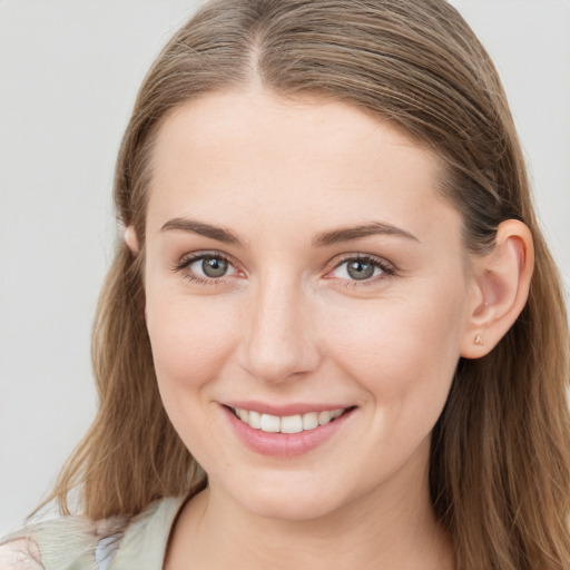 Joyful white young-adult female with long  brown hair and grey eyes